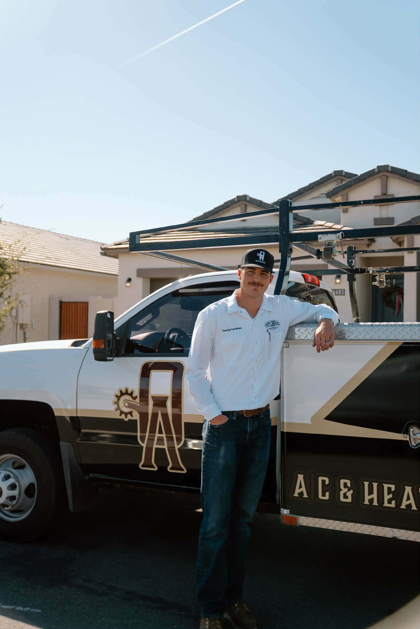 Outlaw Air technician standing beside the Outlaw Air AC & Heating service truck